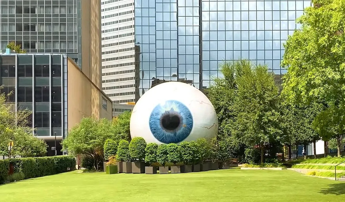 Escultura The Eye, um olho gigante sobre o gramado entre prédios de vidro em Downtown Dallas
