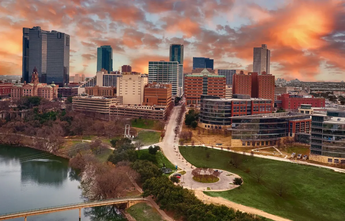 Vista aérea do centro de Fort Worth ao pôr do sol, com o Trinity River e o Tarrant County Courthouse