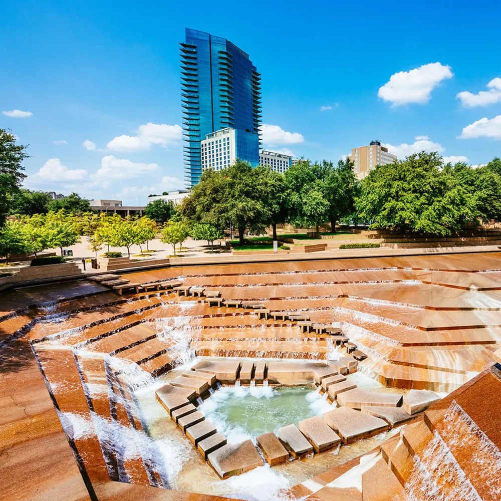 Piscina ativa do Fort Worth Water Gardens, com degraus de concreto e cascatas descendo até o centro