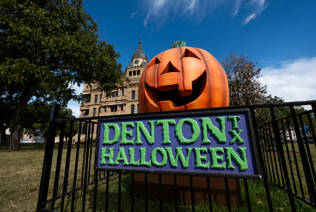 Abóbora gigante e placa Denton TX Halloween em frente ao tribunal histórico de Denton