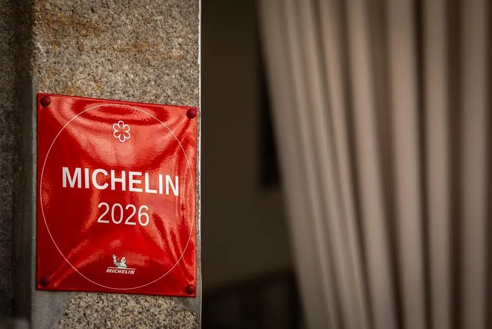 Placa vermelha do Guia MICHELIN 2026 na fachada de um restaurante