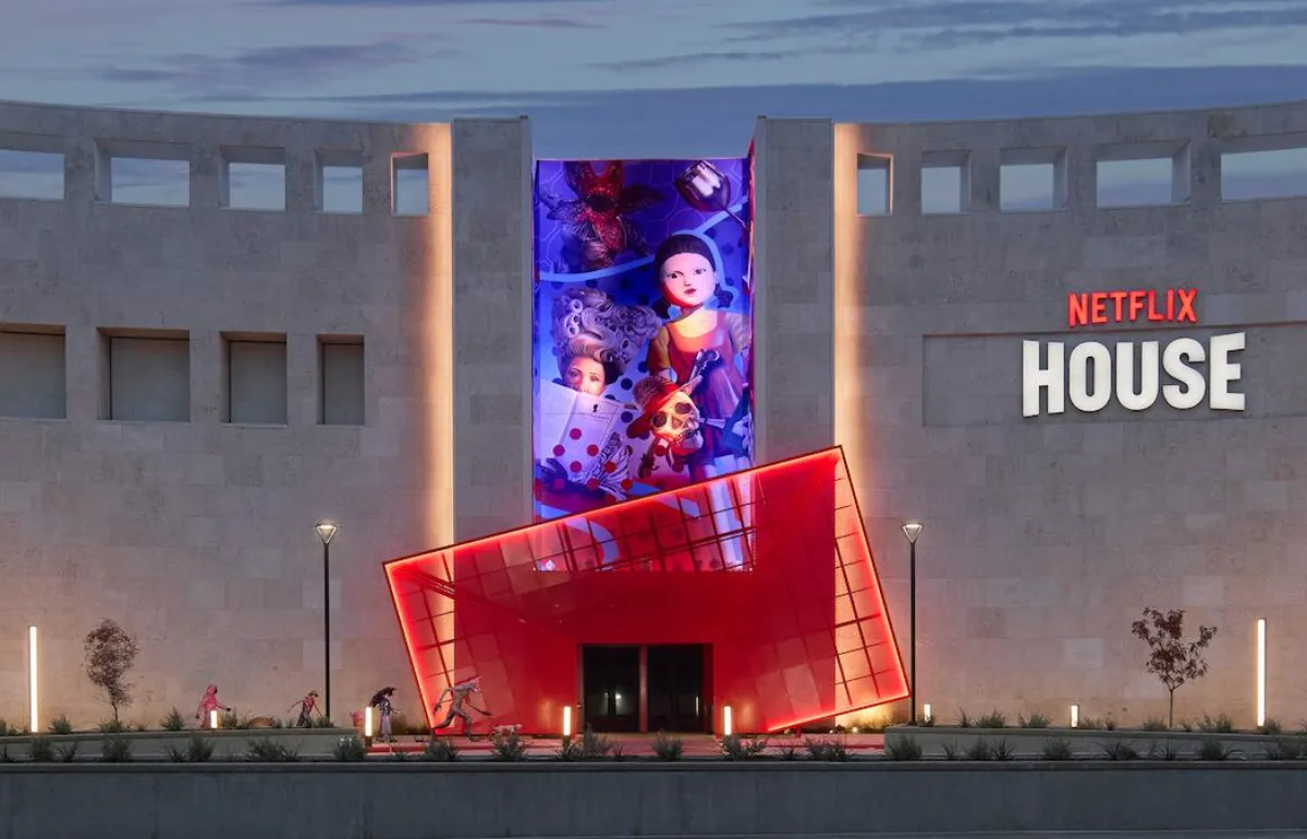 Fachada da Netflix House Dallas iluminada ao anoitecer