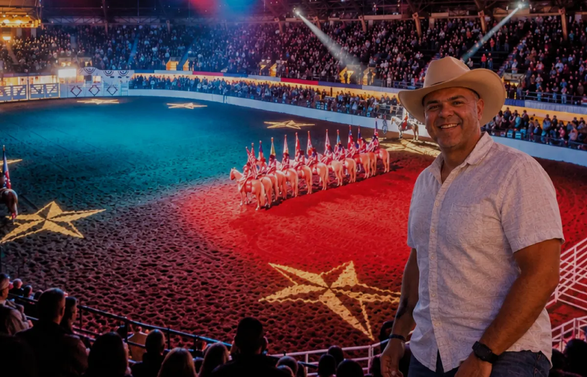 Abertura de rodeio no Texas com bandeiras a cavalo na arena iluminada