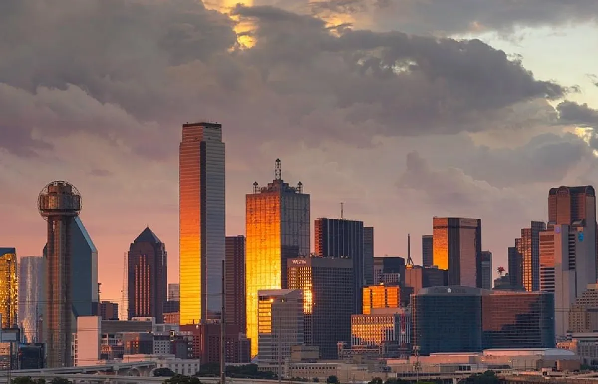 Vista aérea do Downtown de Dallas ao anoitecer, com a Reunion Tower em primeiro plano