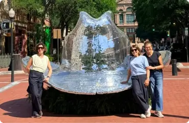 Grupo de brasileiras ao lado da escultura de chapéu espelhado em Sundance Square, Fort Worth
