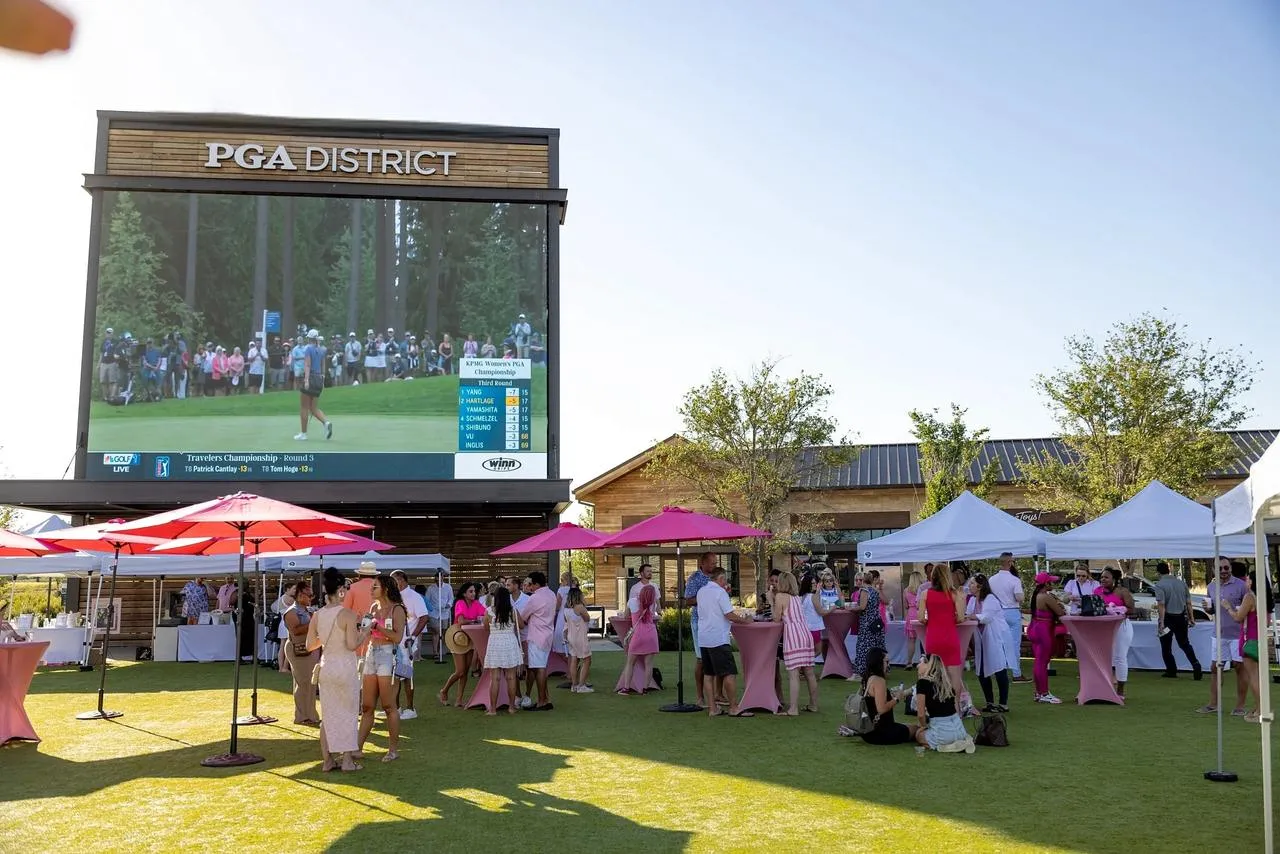 Telão e tendas no gramado do PGA District, em Frisco