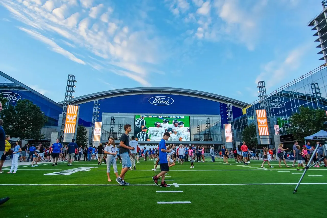 Torcedores no gramado em frente ao Ford Center, no The Star em Frisco