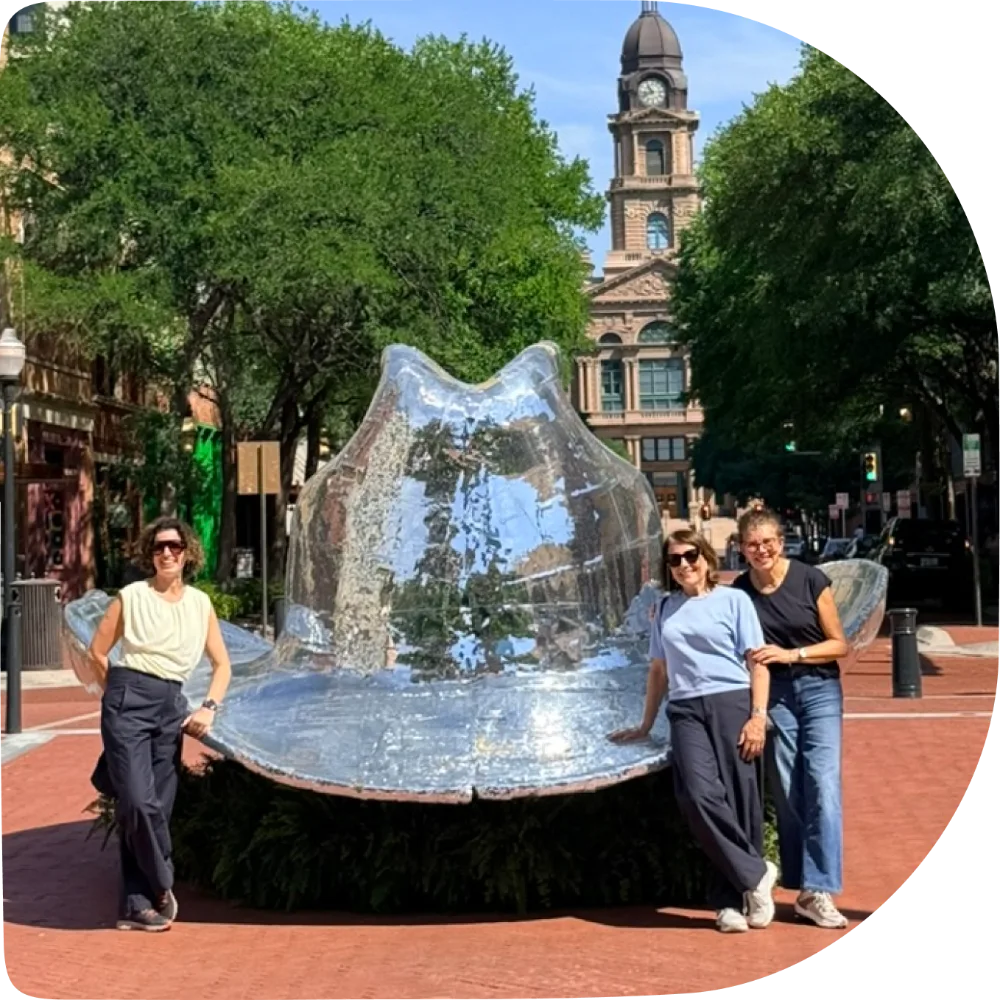 Passeio guiado em Fort Worth: grupo ao lado da escultura de chapéu espelhado em Sundance Square, com o Tarrant County Courthouse ao fundo