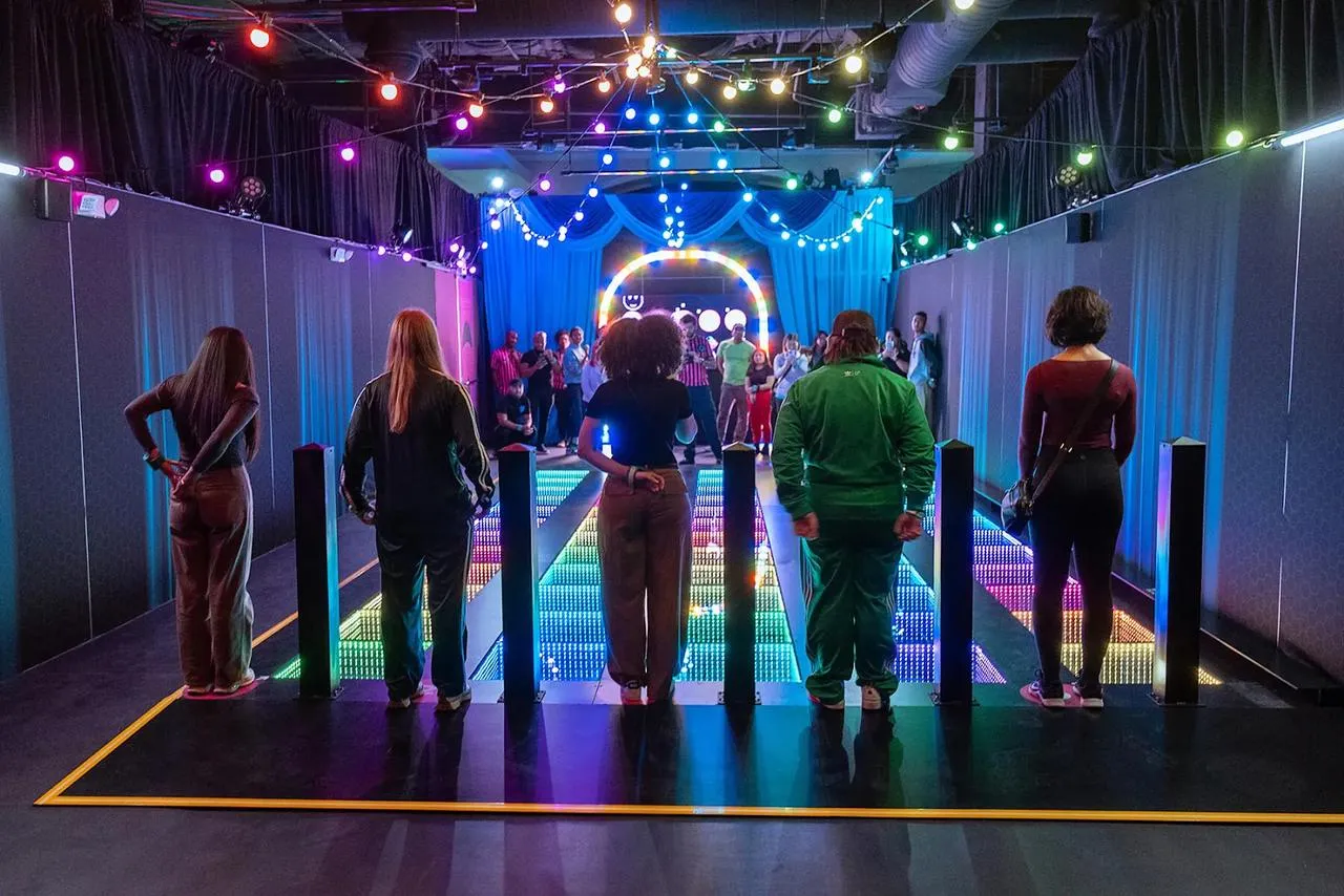 Grupo de amigos em uma pista de luzes coloridas na Netflix House Dallas