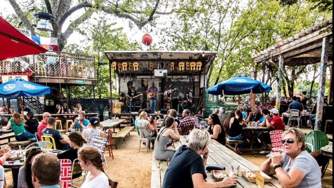 Pessoas comendo no quintal ao ar livre do Truck Yard, na Lower Greenville