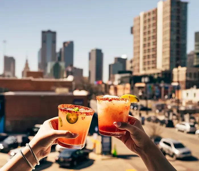Brinde com margaritas em um rooftop de Dallas, com o skyline ao fundo